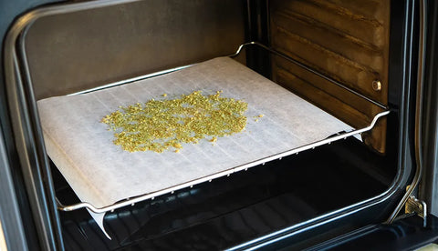 Decarbing cannabis on a sheet of parchment paper in the oven