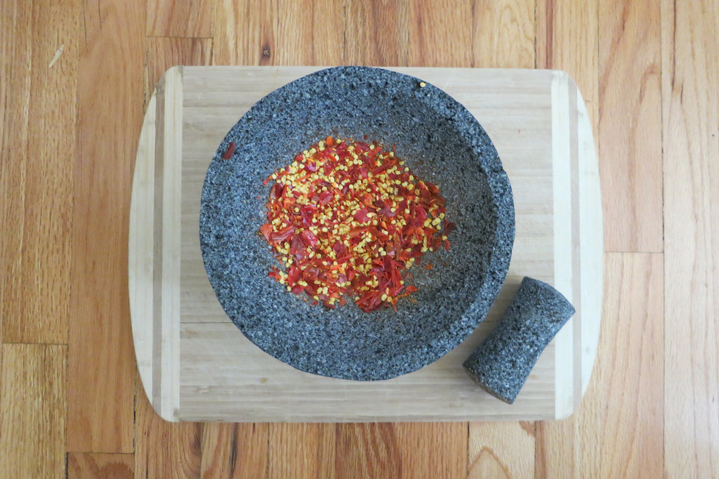 https://cdn.shopify.com/s/files/1/0871/0950/files/Grinding-Peppers-Molcajete_1024x1024.jpg?v=1548276376