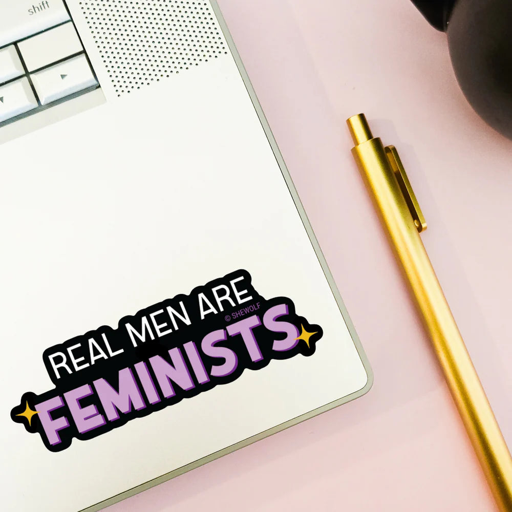 a computer with a sticker that reads "real men are feminists"