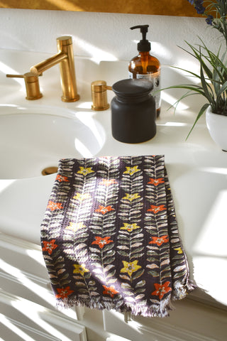 Block printed Selena hand towel folded and placed on a white bathroom counter