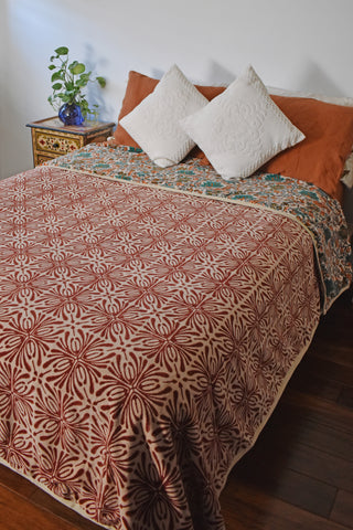 Block printed velvet blanket on a full size bed; red print