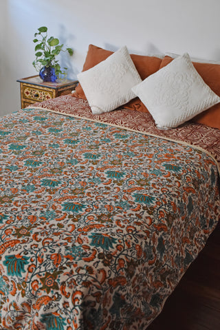 Block printed velvet blanket on a full size bed; green floral print