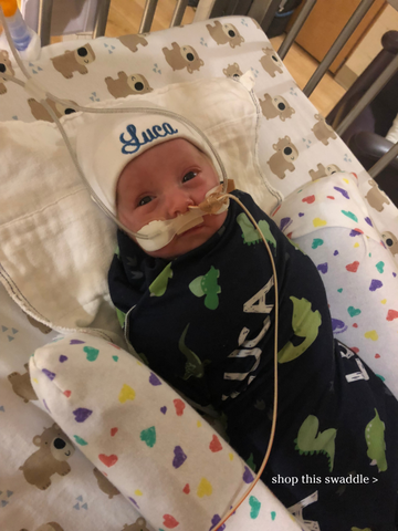 Baby Luca with dinosaur swaddle blanket