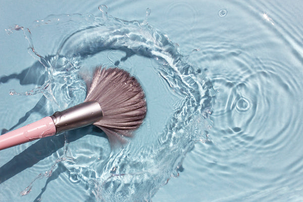 A clean blusher brush swishing in clean water