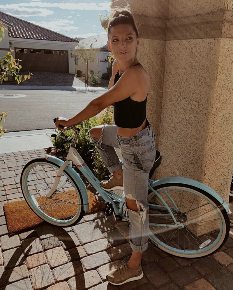 girl riding bike wearing sustainable fashion sneakers