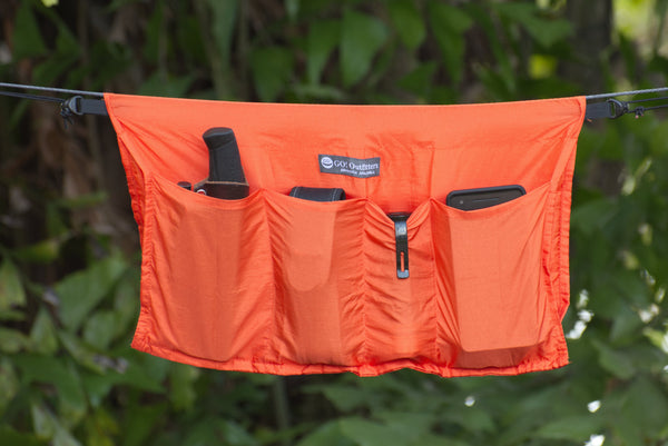image of a burnt orange Hammock Holdall ridgeline organizer with outdoor gear in the pockets
