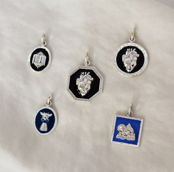 Silver and enamel pendants with Mountain, Human Heart, Sun, Bee, Hive and Book symbols 