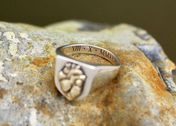 Grabado de fecha con números romanos en el interior del anillo de plata.