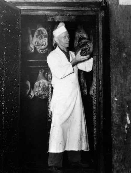 worker placing meat cuts inside the smoke tower