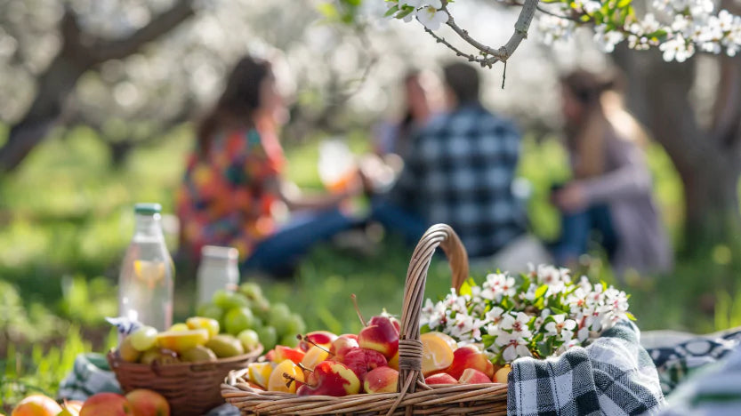 An image of people enjoying their day and having unforgettable moments with their families, with a picnic basket of fresh fruits in an orchard.