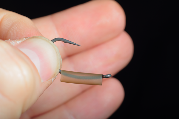 Slide the shrink tubing over the eye and onto the shank of the hook