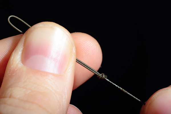 Using your braid stripper tool carefully strip back around 10mm behind the knot of the overhand loop