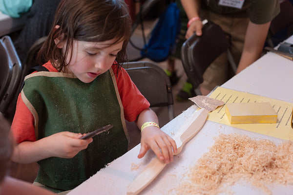 child works on wooden propeller at oshkosh airventure