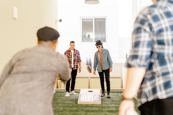 Dapper Boi Model gracefully plays cornhole with a PSL