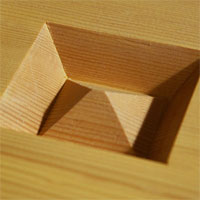 Thick wooden go boards have an unfinished pyramid carved into the bottom to prevent warping. 