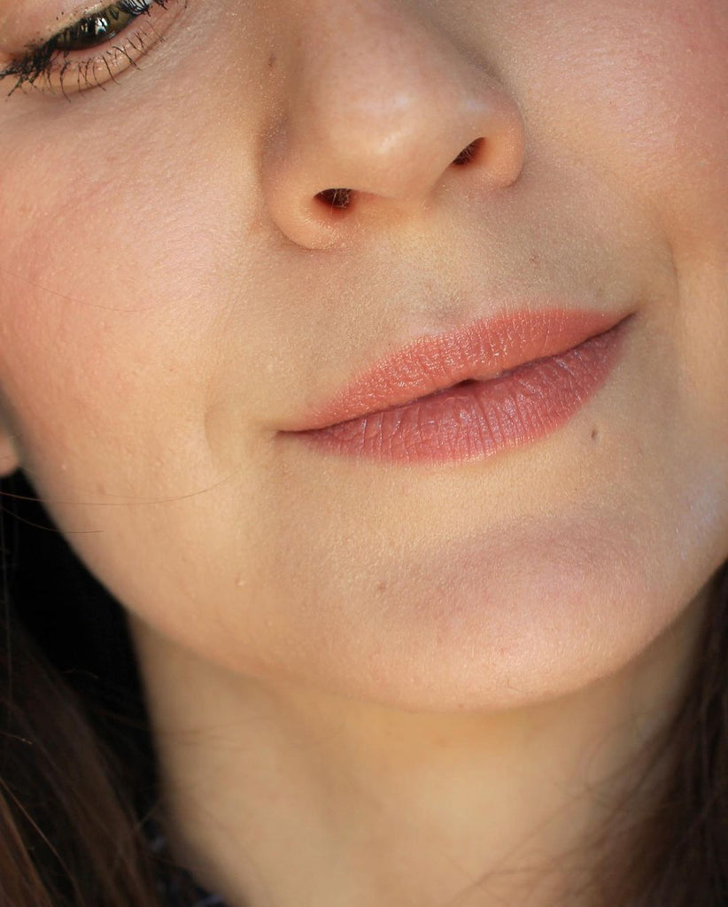 A close up of a girl and her face. It's all about the lips and her lipstick. Wearing a creamy nude color, this is the shade Barcelona. This is Velvet Lip Creme, a matte lipstick by a Canadian brand Saint Cosmetics.