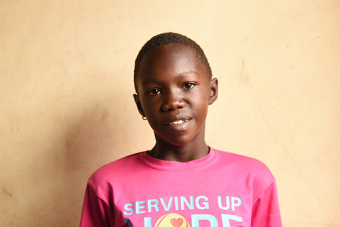 Smiling Ugandan girl in pink shirt