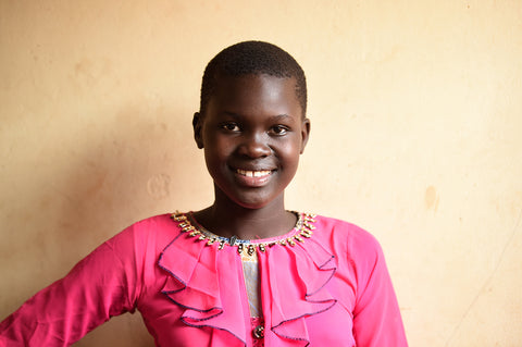 Smiling Ugandan girl wearing a pink shirt