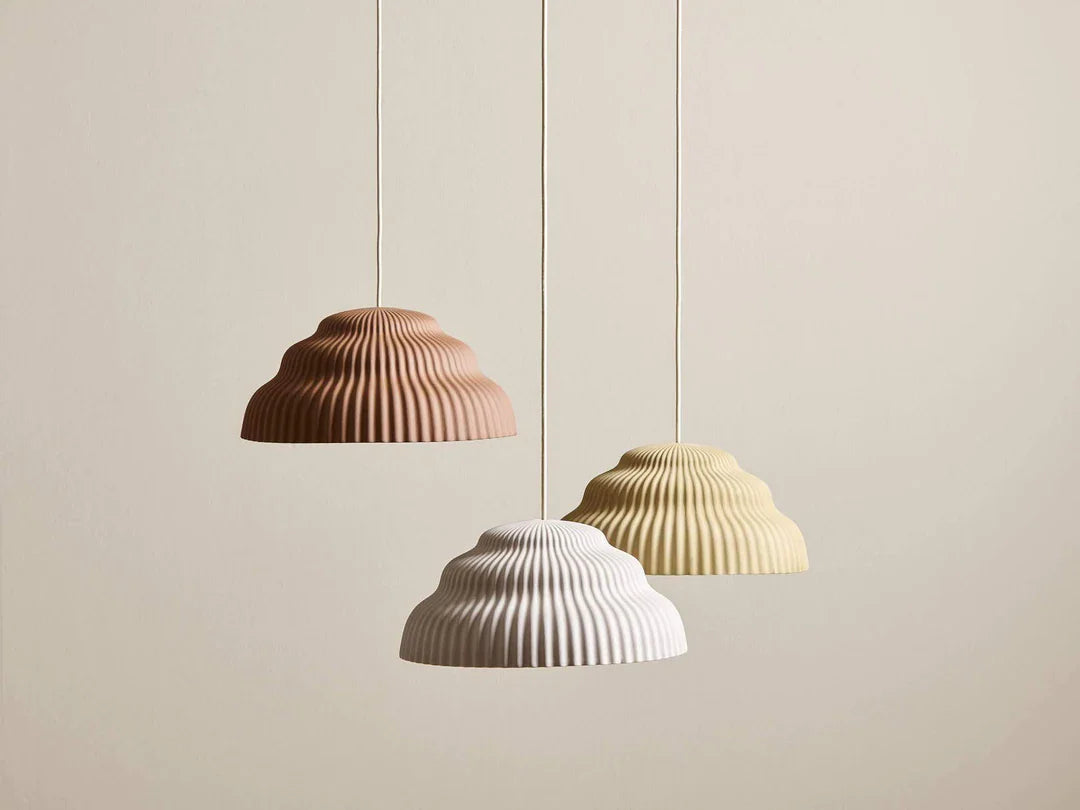 Set of scalloped ribbed ceramic pendant shades in sand, rust, and off-white tones for soft ambience.