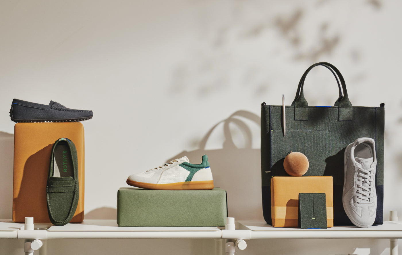 An assortment of Rothy's Driving Loafers, RS01 Sneakers and accessories on a white shelf. 