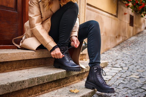 Woman adjusting shoelaces to break in boots