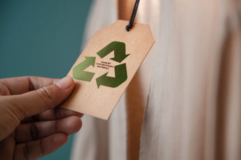 Person reading the tag of organic clothing that’s made from recycled materials