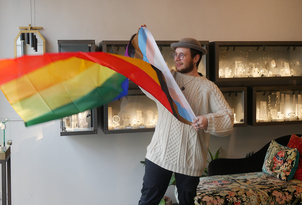 Lukas holding LGBTQIA flag for Queer exhibition Diana Porter Jewellery