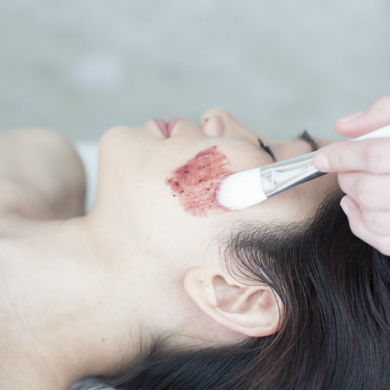 Woman Receiving Chemical Peel At A Medical Spa With A Brush