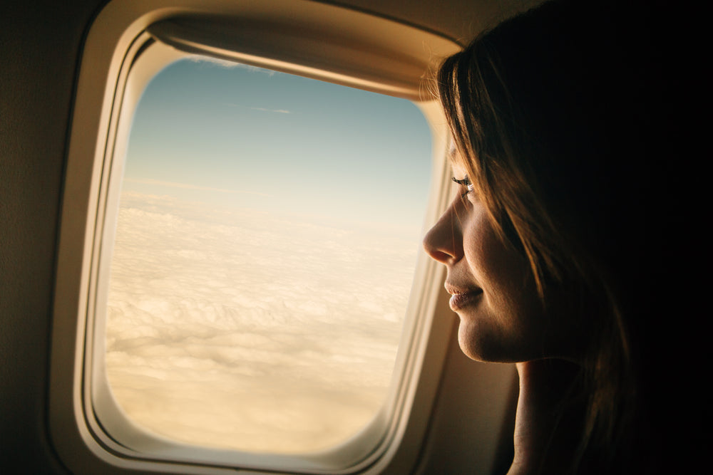 woman looking out plane window
