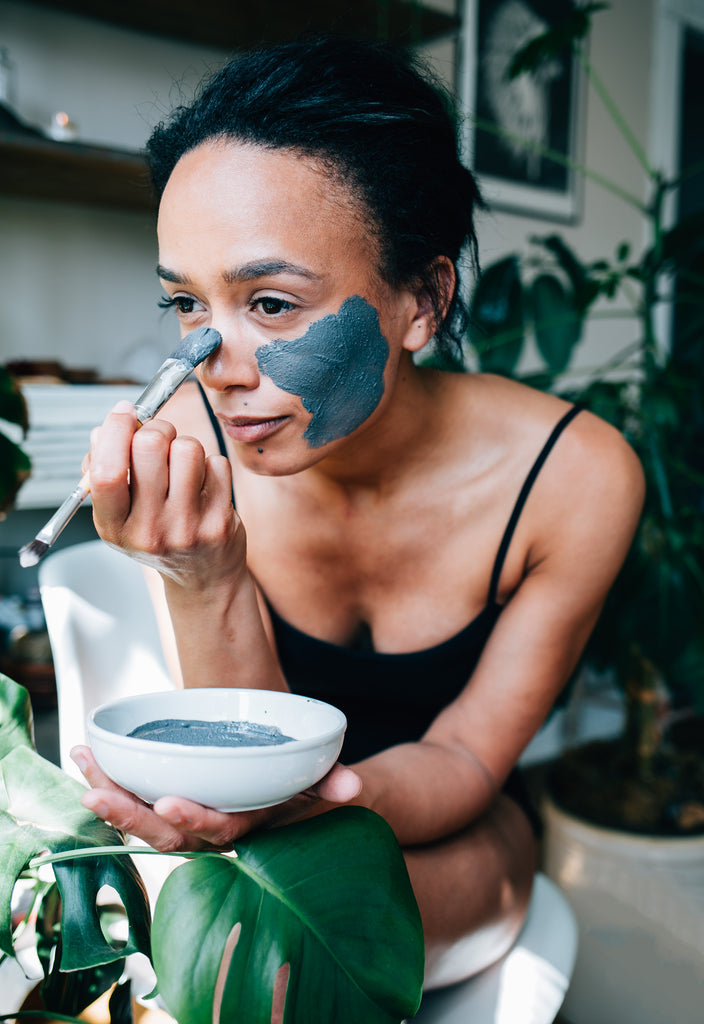 Young woman smiling at camera while wearing the Activated Purifying Mask made from French green clay by natural skincare brand, Apoterra Skincare. 