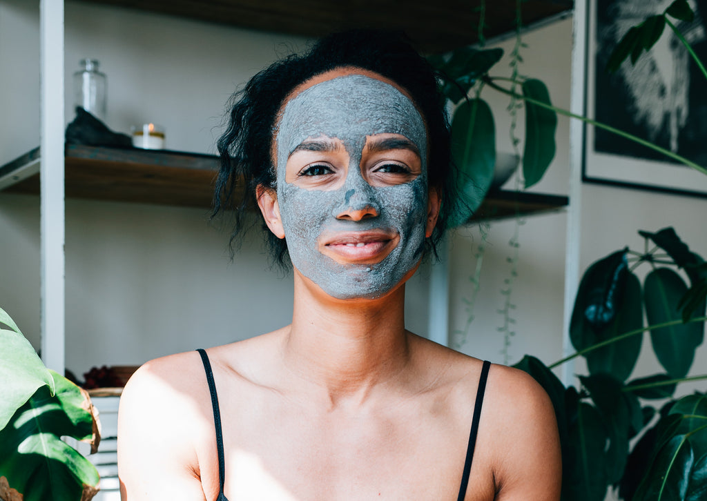 Young woman smiling at camera while wearing the Activated Purifying Mask made from French green clay by natural skincare brand, Apoterra Skincare. 