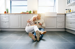 Older couple drinking wine on kitchen floor