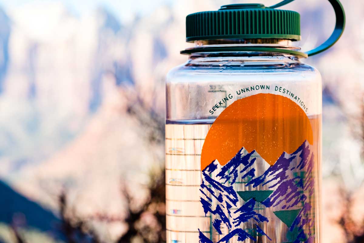 Close up of Nalgene water bottle on hiking trail.