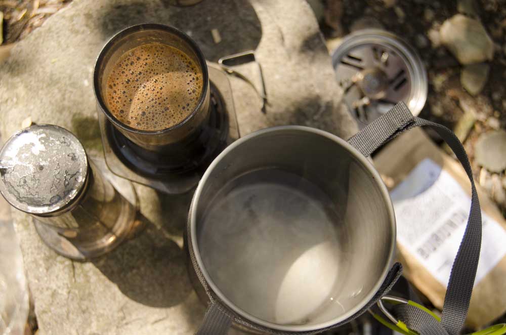 AeroPress Coffee Press brewing on a rock in camp.