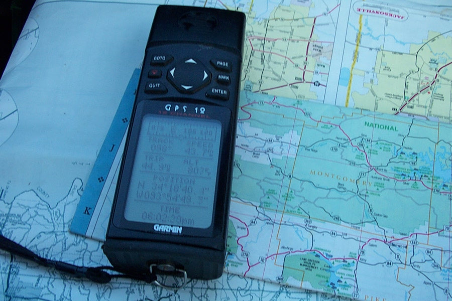 GPS safety device placed on a trail map for adventure planning.