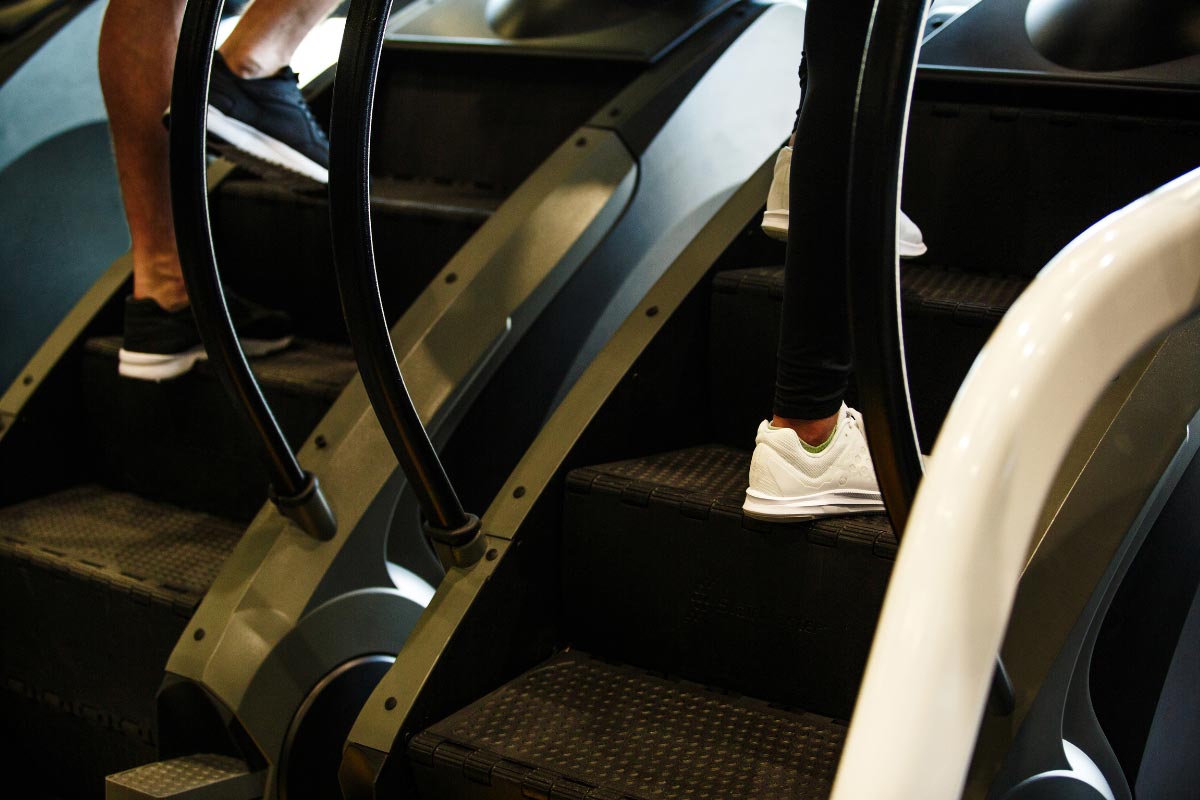 Man and women working out on stair machines.