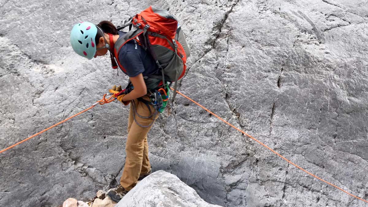 Whitney Thomas attaching harness to climbing rope.