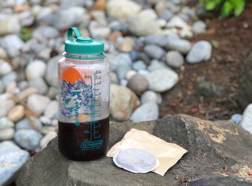 Nalgene bottle with cold brew pack on a rock.