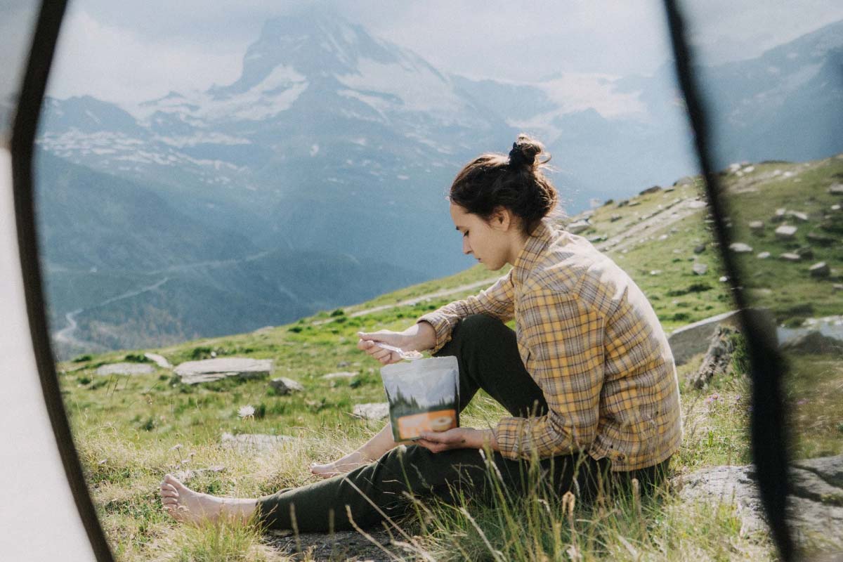Backpacker eating a freeze dried backpacking meal with amazing mountain views.