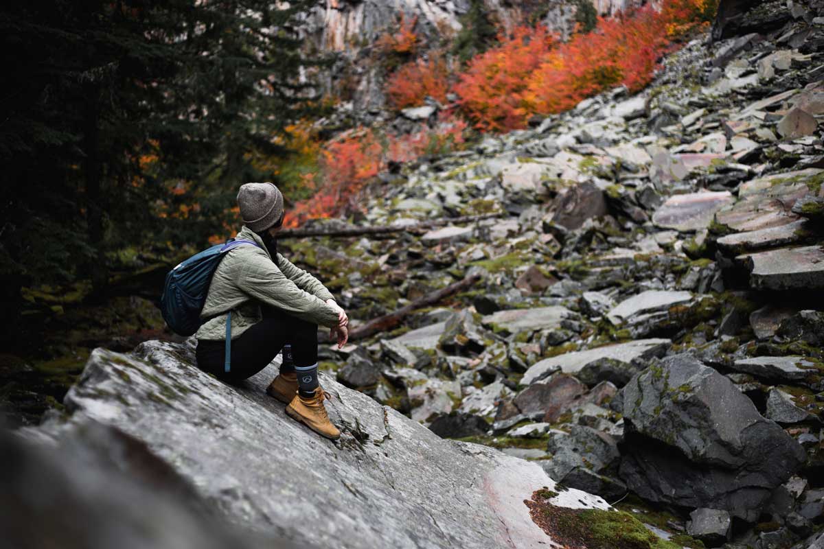 Hiker enjoying view of fall colors wearing Cloudline hiking socks and other outdoor layers.