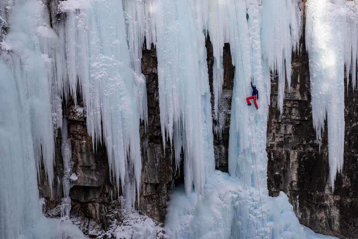 Ice climber midway up a frozen waterfall