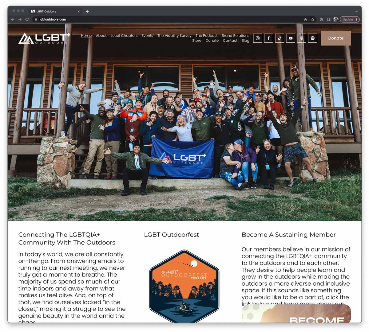 Image of LGBT+ Outdoors website homepage showing group of people on the steps of a cabin and holding up a LGBT+ Outdoors flag.
