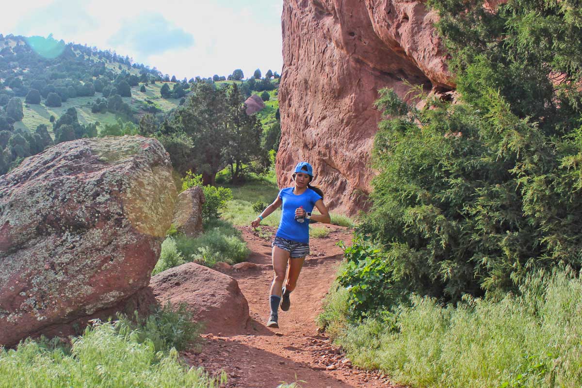 Woman on a trail run during hot day and wearing Cloudline Apparel socks.