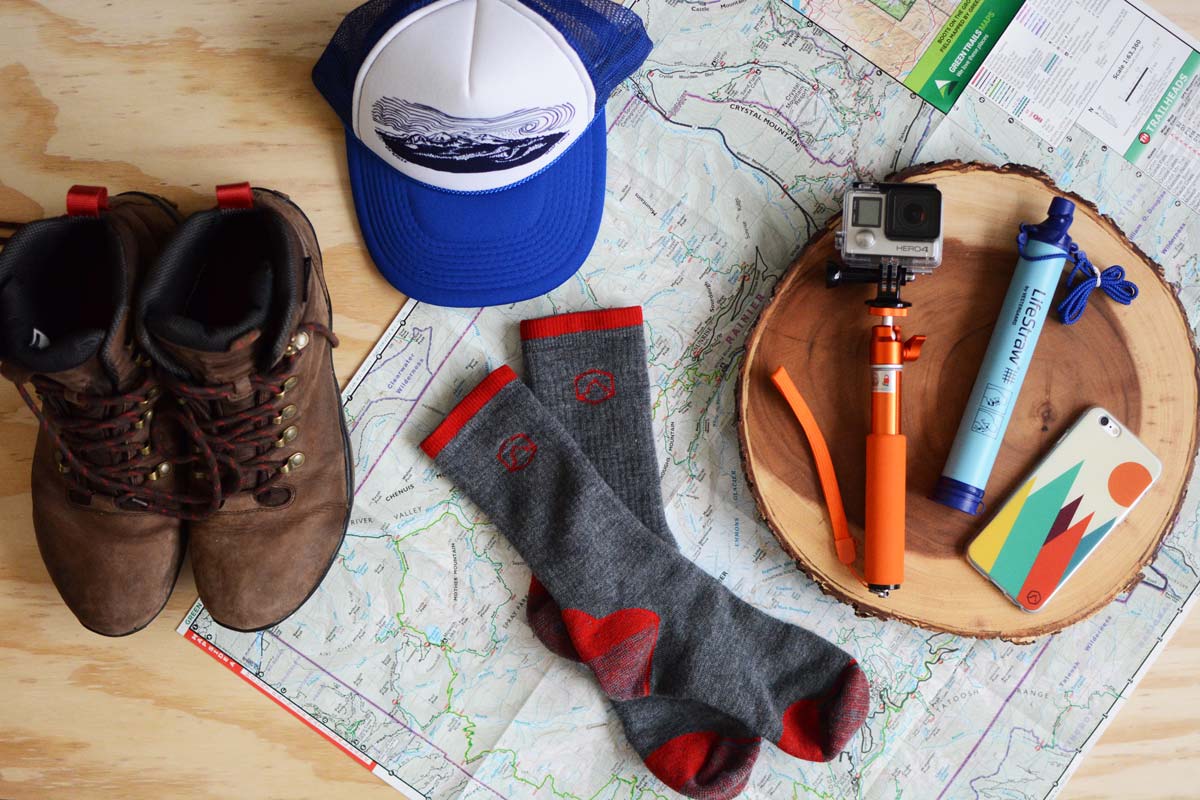 Mt Baker Hat laying on map with Cloudline socks and hiking boots.
