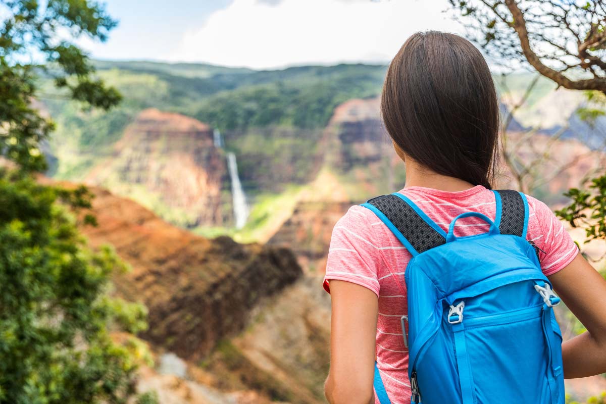 Hiker enjoying a balmy tropical hike with waterfall view.