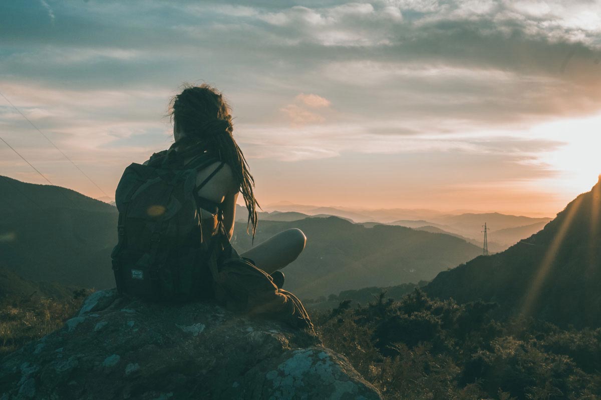 Hiker enjoying sunset view wearing daypack.