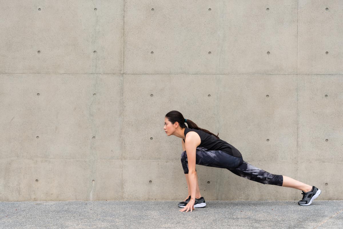 Women doing a runner's lunge stretch.