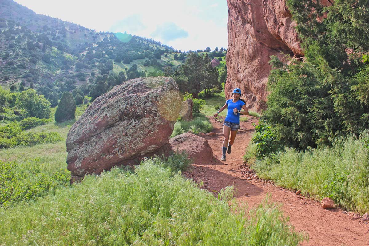 Trail runner running on a hot sunny day wearing breathable Cloudline Apparel wool socks.