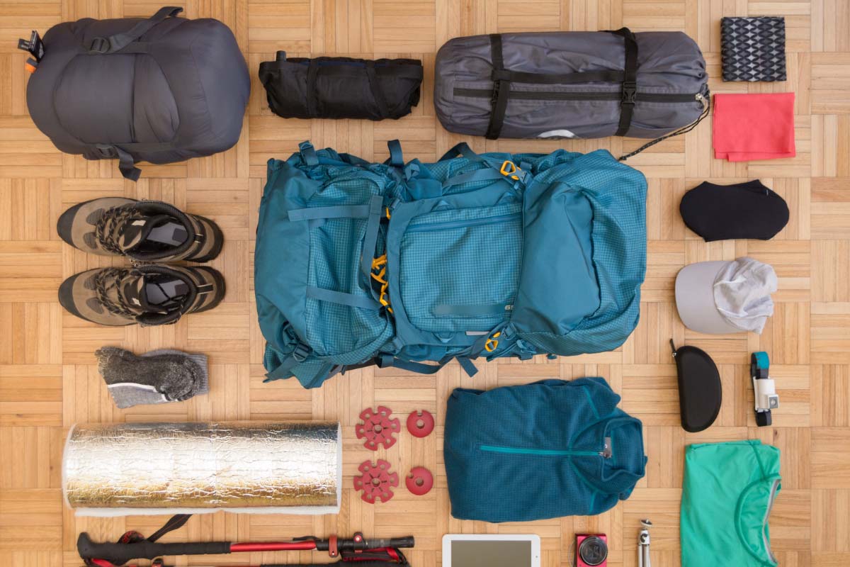 Backpacking gear laid out neatly on the floor.