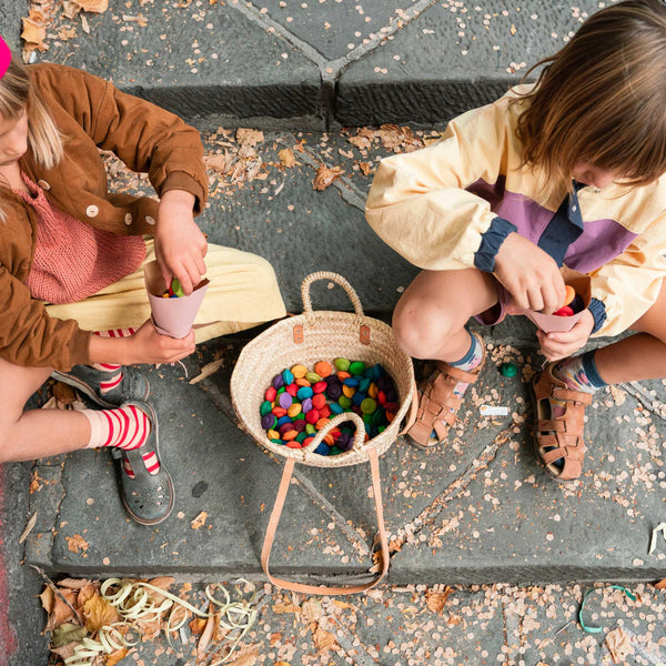 Two children playing with Grapat Mandala pieces.